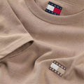 TOMMY JEANS REGULAR BADGE CAMISETA REGULAR FIT COASTAL TAUPE